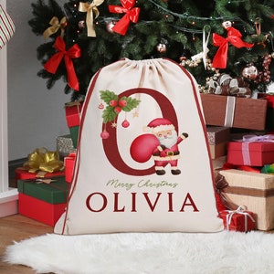 May include: A personalized Christmas stocking with the name "Olivia" printed on it. The stocking is red and white with a Santa Claus illustration and the words "Merry Christmas".