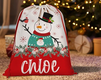 May include: Red and white Christmas gift bag with a snowman design and the name "Chloe" printed on the front.