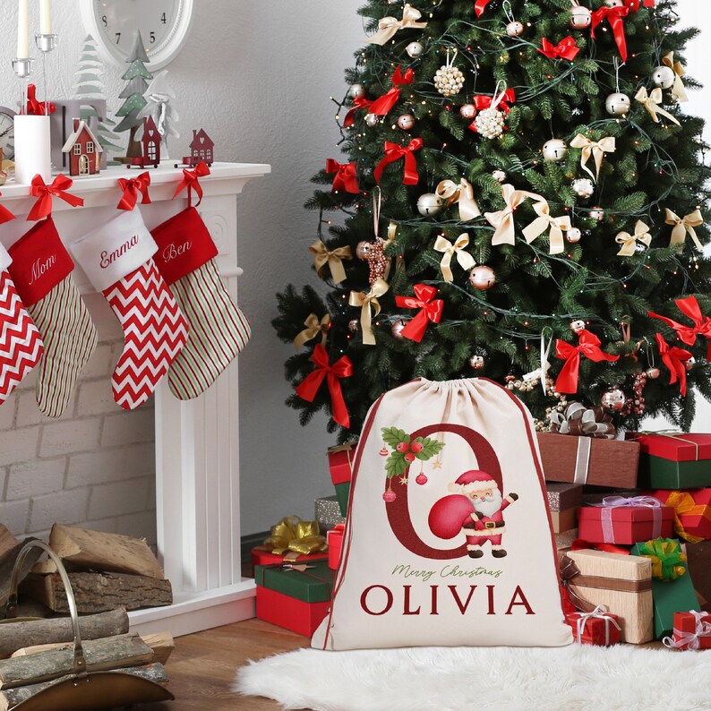 May include: A personalized Christmas stocking with the name "Olivia" printed on it. The stocking is red and white with a Santa Claus illustration and the words "Merry Christmas".