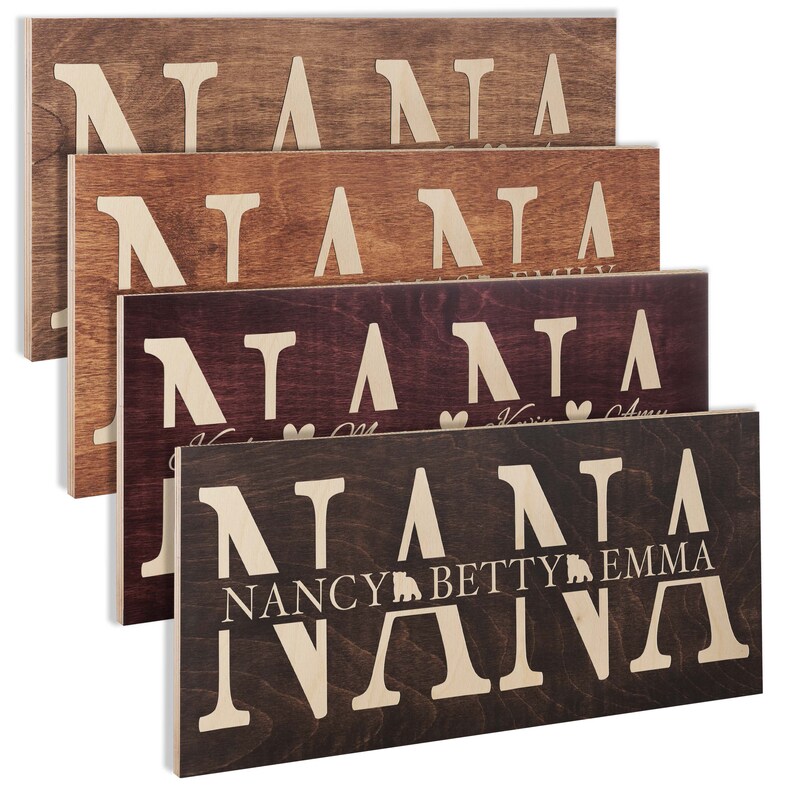 May include: Four wooden signs with the word "NANA" in large white letters. The signs are in different shades of brown and have different names and designs underneath the word "NANA".