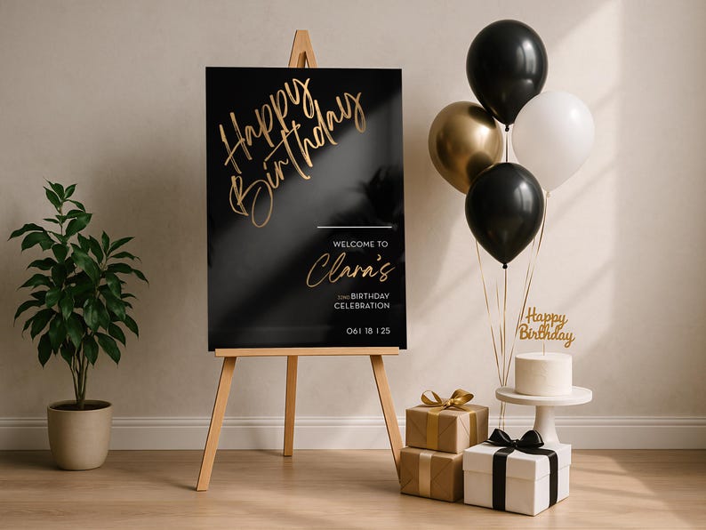 以下が含まれることがあります： 木製のイーゼルに飾られた黒と金の誕生日サイン。 「Happy Birthday」と「Clara's Birthday Celebrationへようこそ」の文字。 風船、ギフト、ケーキが華やかなシーンを演出しています。