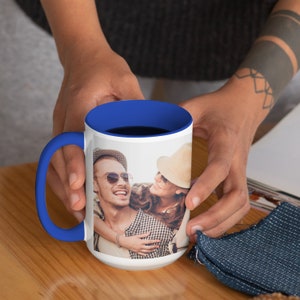 May include: A white ceramic mug with a blue rim, featuring a photo of a couple smiling and hugging. The mug is 15 ounces and is perfect for enjoying a hot beverage.