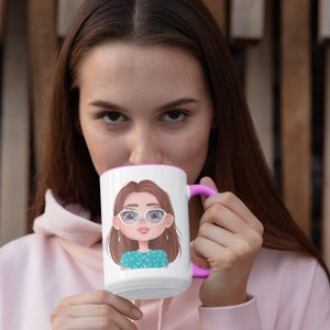 May include: White ceramic mug with a pink rim and handle. The mug features a cartoon illustration of a woman with brown hair wearing glasses and a turquoise shirt with white polka dots.