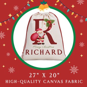 May include: A white canvas Christmas gift bag with a red letter "R" and a cartoon Santa Claus holding a red bag. The bag has the text "Merry Christmas RICHARD" printed on it. The bag is 27 inches by 20 inches.
