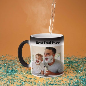 May include: Black and white color changing mug with a photo of a father and son laughing. The mug reads "Best Dad Ever" in black text.
