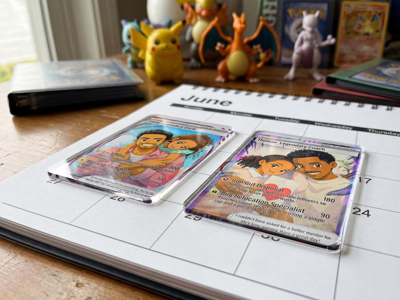 Pode incluir: Duas cartas colecion&aacute;veis personalizadas com ilustra&ccedil;&otilde;es de um casal, em uma p&aacute;gina do calend&aacute;rio de junho. Uma carta diz "Deep Legendary Dude", a outra "Thomas - Legendary Coach". Figuras de Pok&eacute;mon vis&iacute;veis ao fundo.