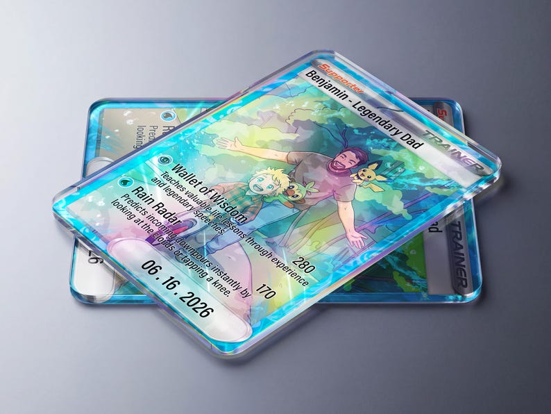 Pode incluir: Duas cartas de acr&iacute;lico transparente com uma ilustra&ccedil;&atilde;o colorida de um pai e uma crian&ccedil;a com personagens Pok&eacute;mon. A carta superior diz "Benjamin - Legendary Dad" e inclui texto sobre li&ccedil;&otilde;es de vida e previs&atilde;o de chuva. A data "06.16.2026" &eacute; vis&iacute;vel.