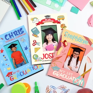 May include: Three graduation photo frames with colourful borders and illustrations. The frames are decorated with school supplies, stars, and the text "My 1st Graduation". Each frame features a child wearing a graduation cap and gown.