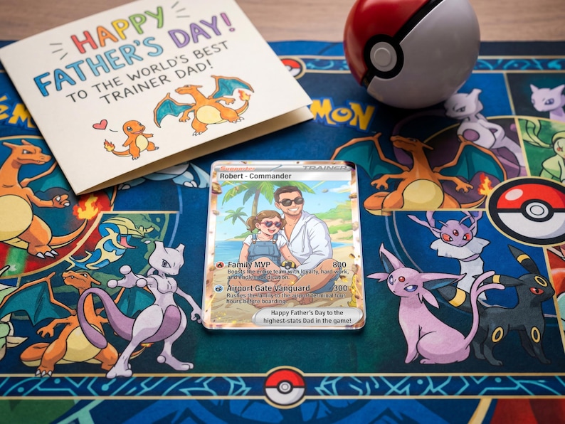 Pode incluir: Um cart&atilde;o de Dia dos Pais com o texto "Happy Father's Day! To the World's Best Trainer Dad!" est&aacute; ao lado de um cart&atilde;o Pok&eacute;mon personalizado. Uma Pok&eacute; Bola vermelha e branca est&aacute; em um tapete azul com personagens Pok&eacute;mon.