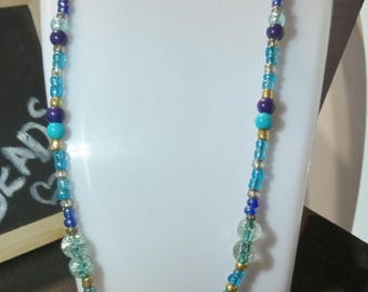 A pretty blue and golden beaded necklace.