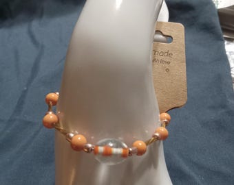 An orange and golden beaded bracelet.