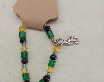 A cats eye green yellow and black beaded bracelet with a cat charm.