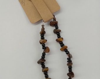 A tigers eye and black beaded bracelet.