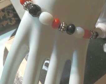 An orange, white and black beaded bracelet.