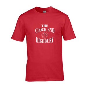 May include: A red t-shirt with white text that reads "THE CLOCK END HIGHBURY". The design includes a clock graphic. The shirt is a short-sleeved crew neck.