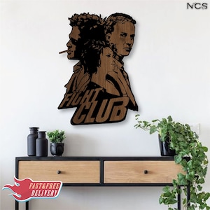 May include: A wooden wall decor featuring a silhouette of three people with the text "Fight Club" in a brown wood finish.