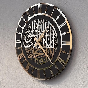 May include: A black and gold wall clock with Roman numerals and Arabic calligraphy. The clock has a mirrored surface and gold hands.