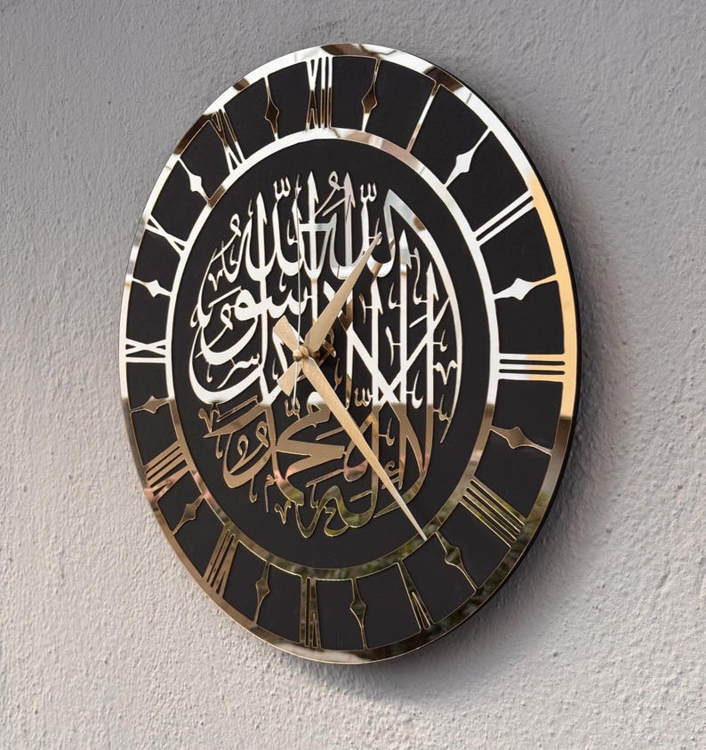 May include: A black and gold wall clock with Roman numerals and Arabic calligraphy. The clock has a mirrored surface and gold hands.