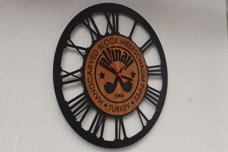 May include: Black and brown wall clock with Roman numerals and a wooden center featuring the text "Handcarved Block Meerschaum Pipes Turkey 1964".