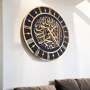 May include: A black and gold wall clock with Roman numerals and Arabic calligraphy. The clock has a black background and gold accents.