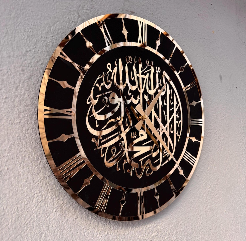 May include: A black and gold clock with Roman numerals and Arabic calligraphy. The clock face features the Islamic phrase "Allah" in gold lettering.