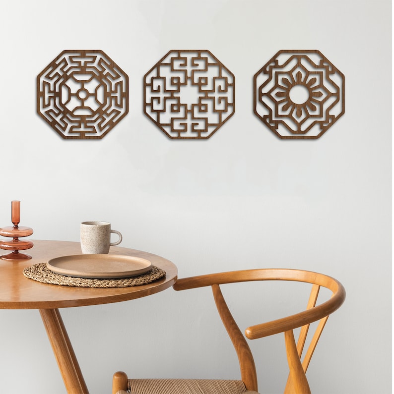 May include: Three wooden wall decorations in the shape of octagons with intricate geometric designs. The designs are in a dark brown colour and are set against a white wall.