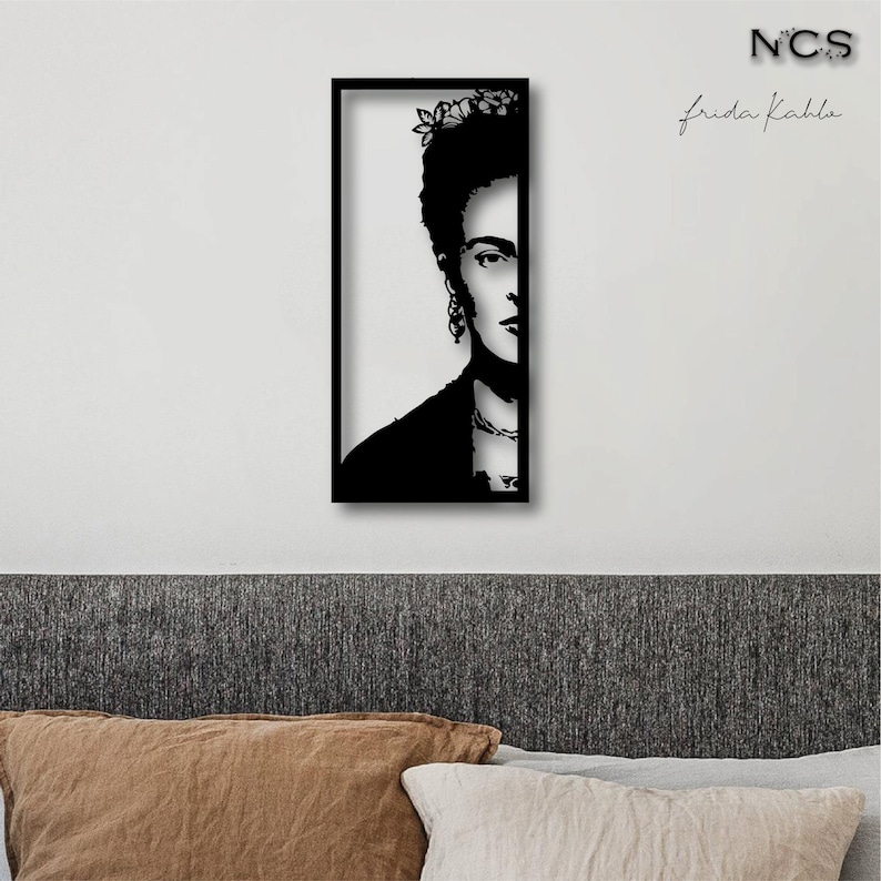 May include: Black and white silhouette of Frida Kahlo's face in a black frame. The image is titled "Frida Kahlo" and has the initials "NCS" in the top right corner.
