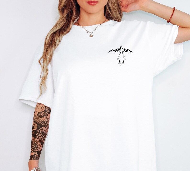 A woman wearing a white t-shirt with a graphic design on the front.
