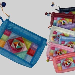 May include: A set of ten colorful zippered pouches with a patchwork design. The pouches are made of a sheer fabric and have a variety of colors, including blue, pink, purple, and white.