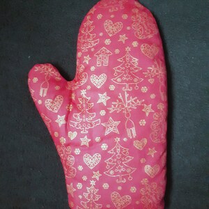 Puede incluir: Manopla de horno roja con un patrón de árbol de Navidad y copo de nieve dorado.