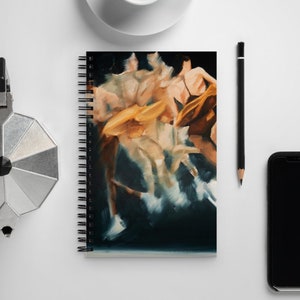 Könnte beinhalten: Spiralgebundenes Notizbuch mit einem abstrakten Gemälde von Figuren in Bewegung, vor dunklem Hintergrund und warmen Farbtönen. Das Bild befindet sich auf einer weißen Oberfläche, zusammen mit einer Kaffeetasse, einem Bleistift, einem Smartphone und einer silbernen Kaffeemaschine.