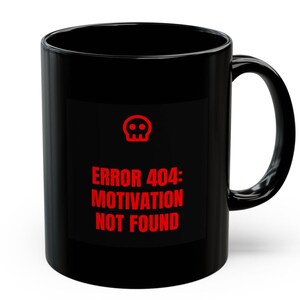 以下が含まれることがあります： 赤いスカルアイコンと「ERROR 404: MOTIVATION NOT FOUND」のテキストが赤色でプリントされた黒いセラミックマグカップ。マグカップは湾曲したハンドルと円筒形をしています。