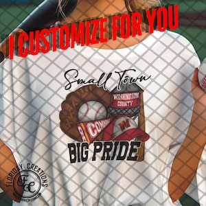 May include: White t-shirt with a baseball-themed design. The design features a baseball glove, a baseball, a water tower with the text "Washington County", a baseball cap, and a pennant. The text "Small Town Big Pride" is printed below the design.