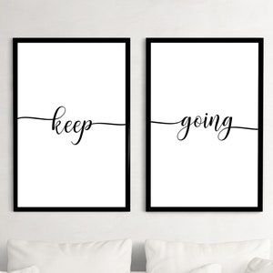 Puede incluir: Dos impresiones enmarcadas en negro con fondos blancos. La impresión de la izquierda dice "keep" y la impresión de la derecha dice "going".