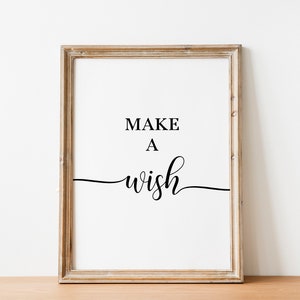 May include: A framed print with the text "MAKE A WISH" in black cursive font on a white background.