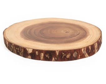 May include: A circular wooden platter with a dark brown central area and a lighter brown outer section. The edge of the platter has a rough, bark-like texture. This decorative item is suitable for serving or displaying items.