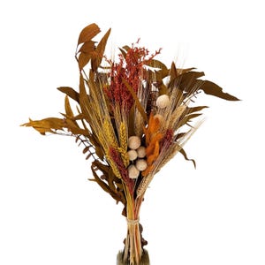 May include: A dried flower bouquet with wheat, dried leaves, and small white and orange flowers.