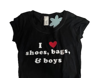 May include: Black cropped t-shirt with a white graphic that says "I love shoes, bags, & boys".