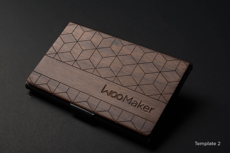 May include: A dark brown wooden card holder with a geometric pattern and the text "wooMaker" engraved on the front.