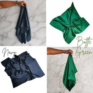 K&ouml;nnte beinhalten: Zwei Seidenschals, einer in Marineblau und einer in Flaschengr&uuml;n, werden gefaltet und von H&auml;nden gehalten gezeigt. Der Text "Navy" und "Bottle Green" steht unter jedem Schal.