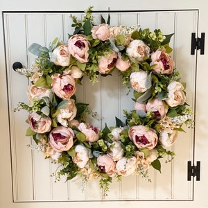 Corona de peonías de color rosa pálido y marfil