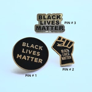 Black Lives Matter geëmailleerde reversspeld met gouden rand en vette letters. Zwarte geschiedenis