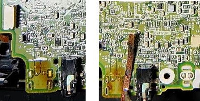 May include: Close-up of a green circuit board with various electronic components. The board has a black audio jack and several small, silver-colored components. There is a brown, rectangular object partially obscuring the board.