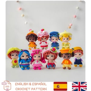 May include: Eleven colourful, handmade crochet dolls are displayed, each with distinct hairstyles and outfits. The dolls feature hats and dresses, with details such as strawberries and flowers. The image includes text that says "ENGLISH & ESPAÑOL CROCHET PATTERN".