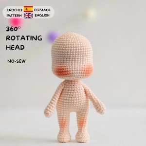 May include: A light beige crochet doll figure with a large rounded head, small arms, and legs. The doll features soft orange blush on the cheeks and knees. Text on the image reads: CROCHET PATTERN ESPAÑOL ENGLISH, 360° ROTATING HEAD, NO-SEW.