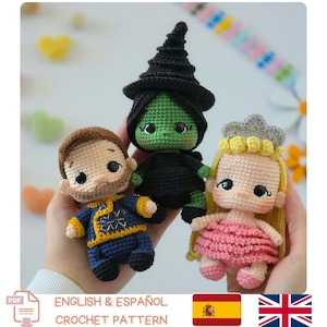 May include: Three small amigurumi dolls crocheted with yarn. One doll has brown hair and a blue and yellow outfit. The second doll is green with a black pointed hat and black clothing. The third doll has long blonde hair, a gray crown, and a pink dress.