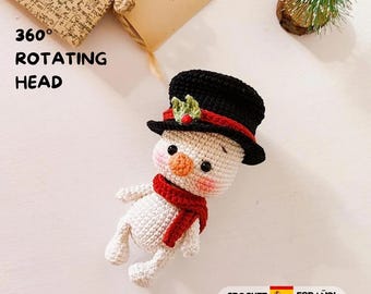 May include: A crocheted snowman doll with a 360 degree rotating head, wearing a black top hat with a red band and green holly, and a red scarf. The snowman has a round orange nose, black eyes, and pink cheeks. Text reads 360 ROTATING HEAD.
