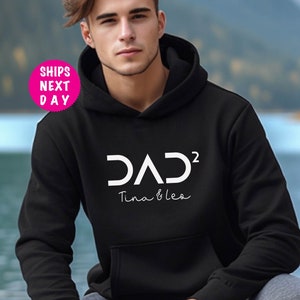 May include: Black hooded sweatshirt with white text that reads "DAD² Tina & Leo".