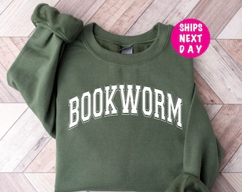 May include: A green sweatshirt with the word "BOOKWORM" printed in white on the front.