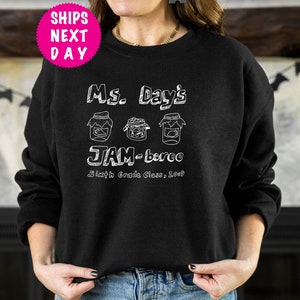 May include: Black sweatshirt with white text that reads "Ms. Day's JAM-boree Sixth Grade Class, 2009" and three jars with lids.